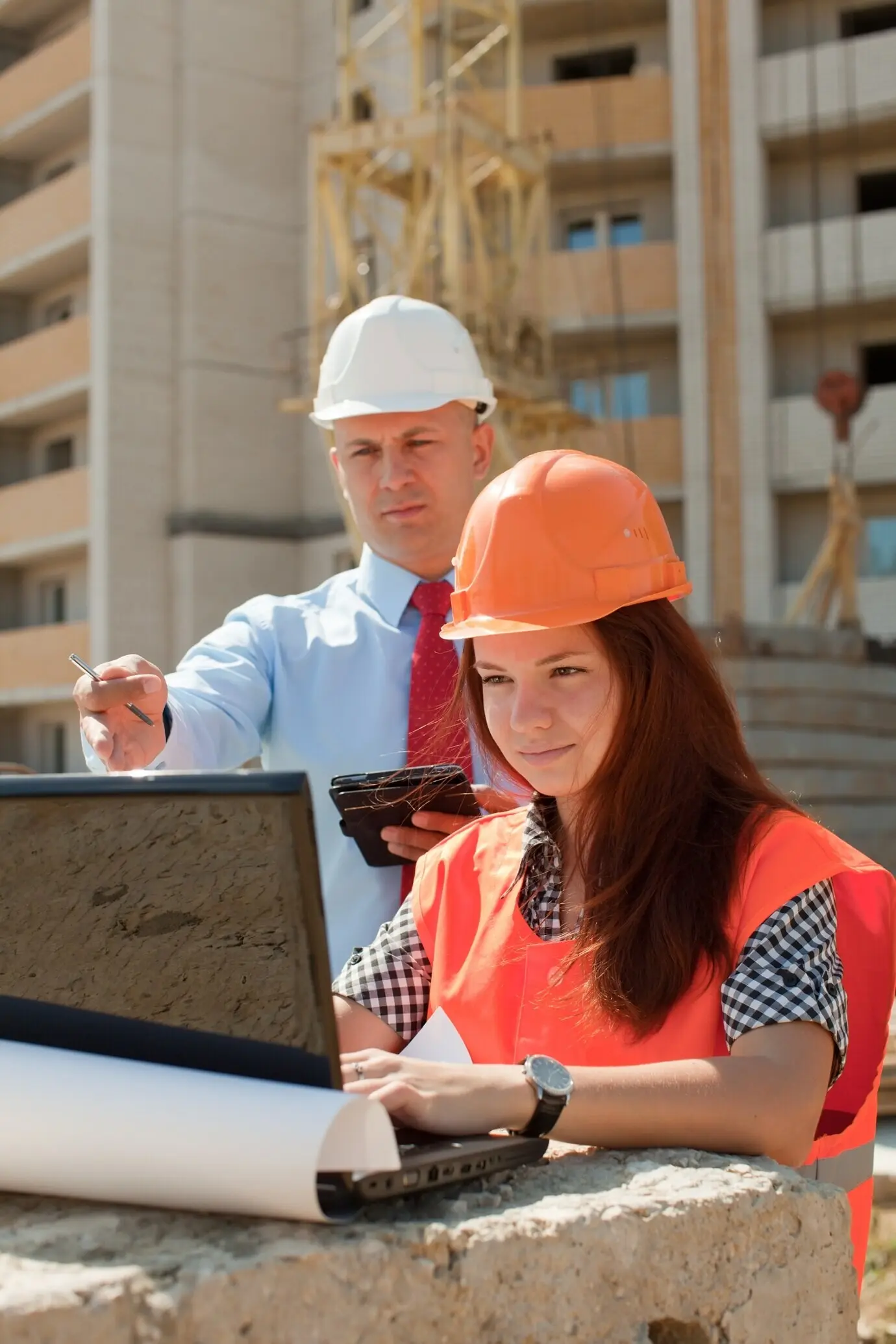 White-collar employees are working at a construction site.